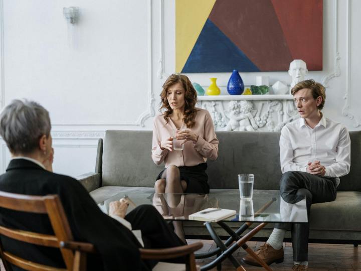 woman in pink long sleeve shirt sitting on gray couch
