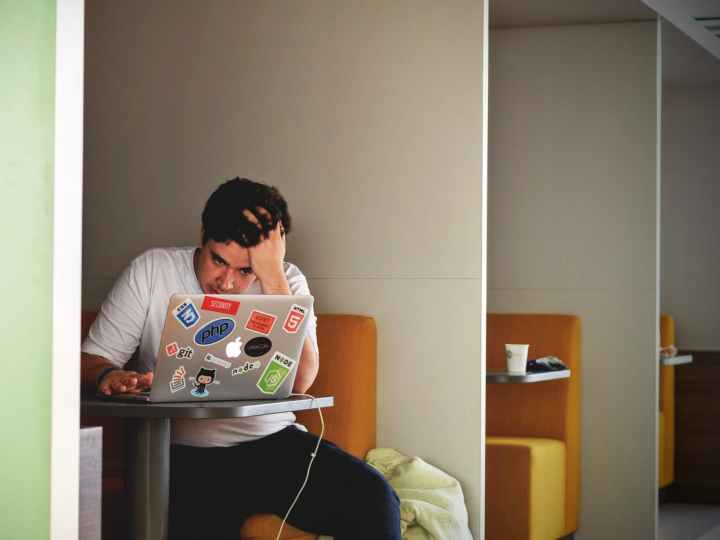 man in white shirt using macbook pro