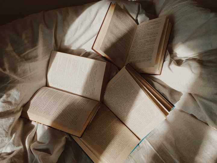 opened books placed on disheveled bed